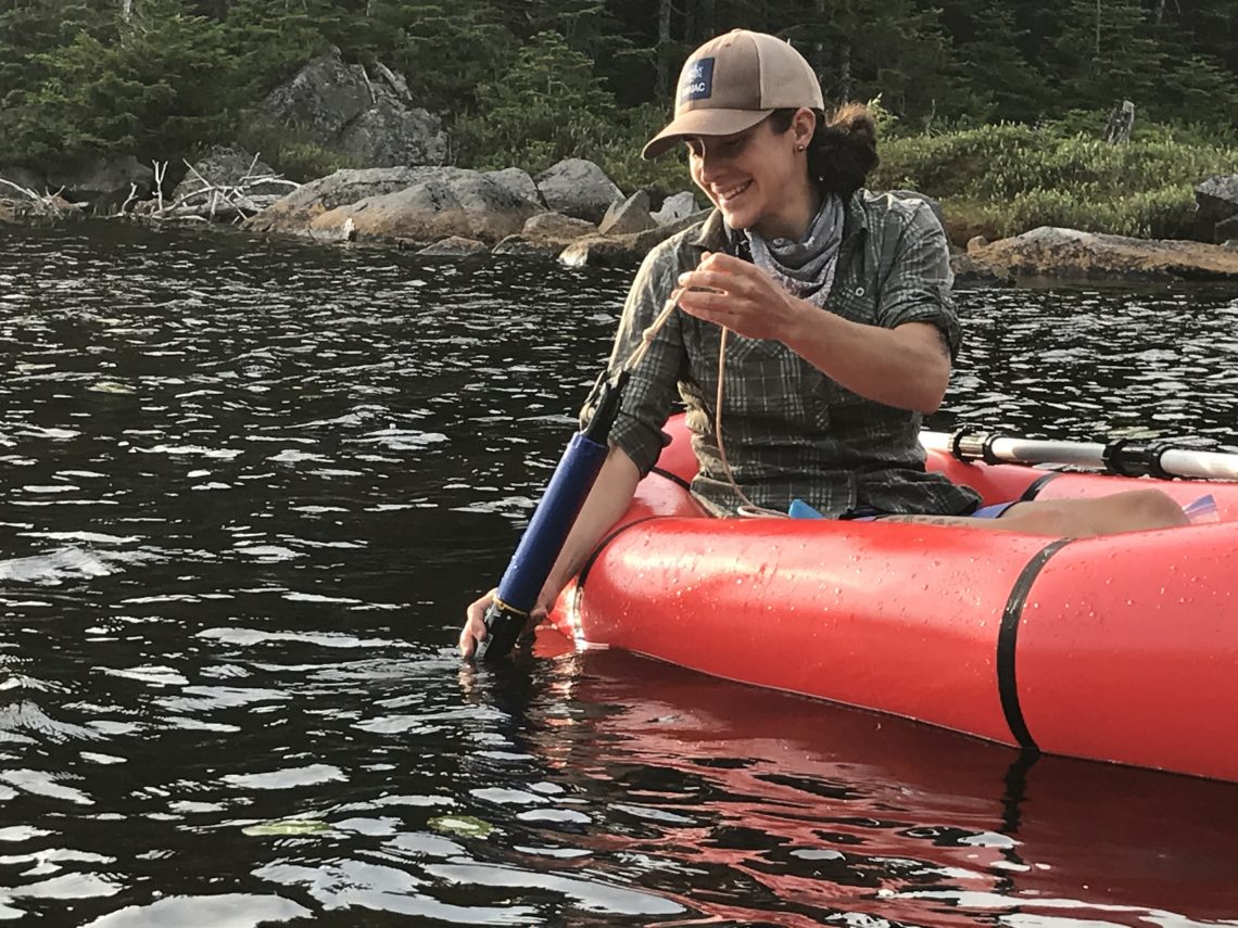 Rachel Hovel, UMF assistant professor of biology, uses a sonde to collect water quality information on Horns Pond in the Bigelow Range.